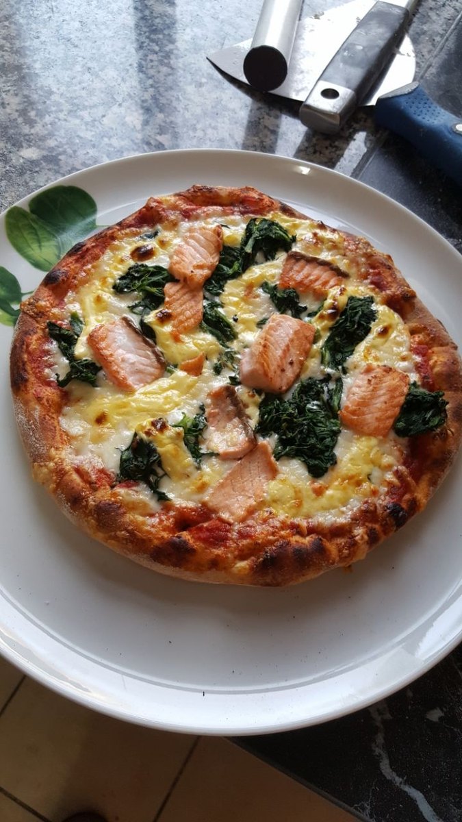 Frisch gebackene Pizza mit Lachs und Spinat